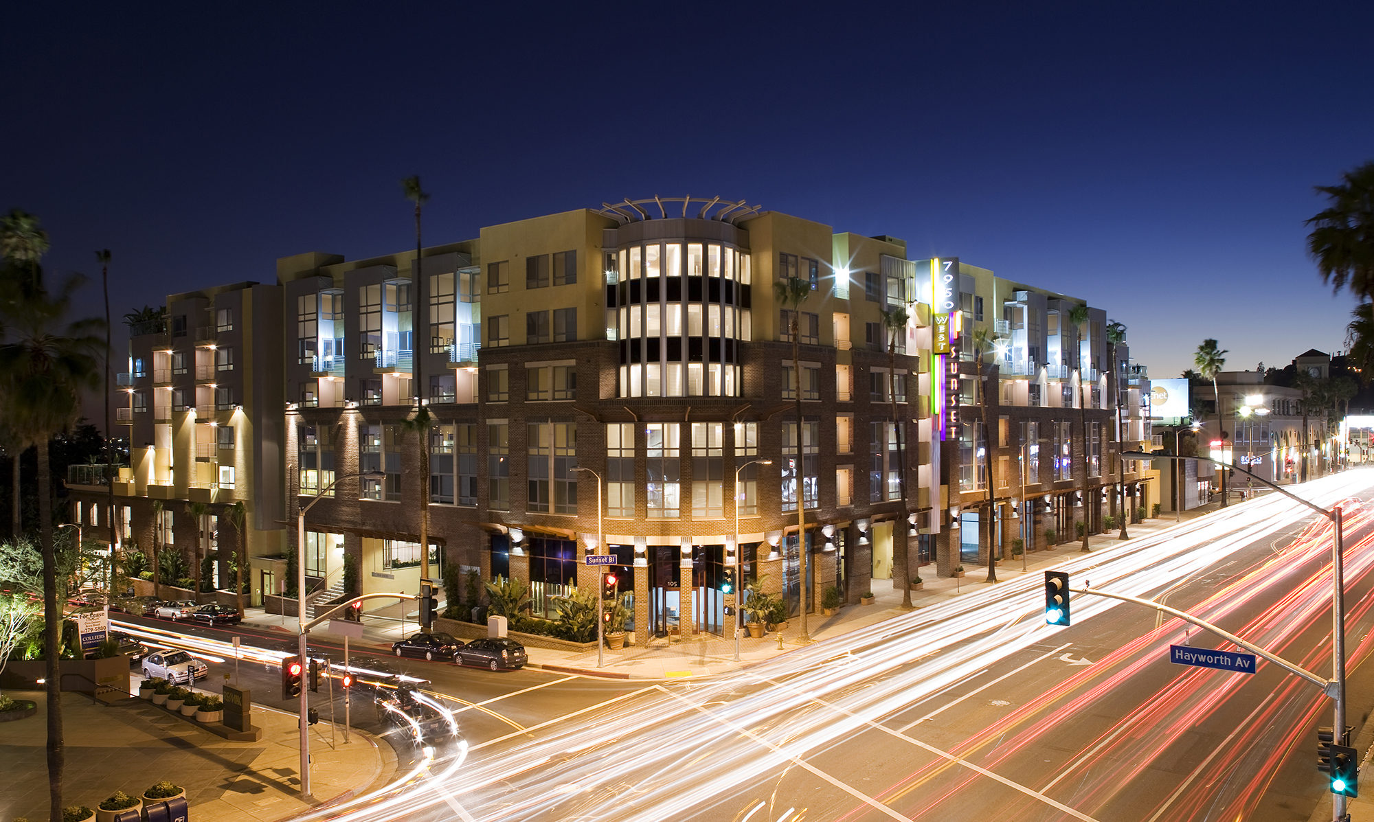Exterior shot of podium building with city and street lights
