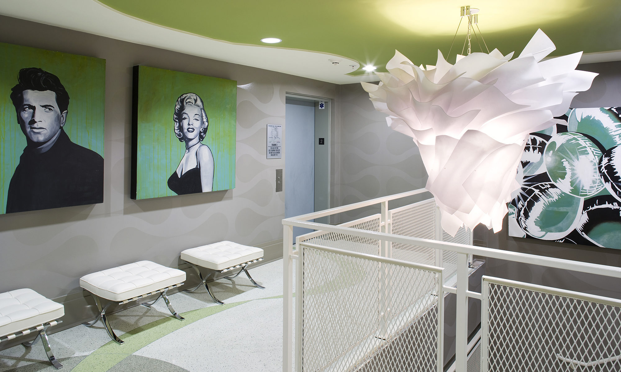 Blue elevator door surrounded by concrete walls and green accent colors.