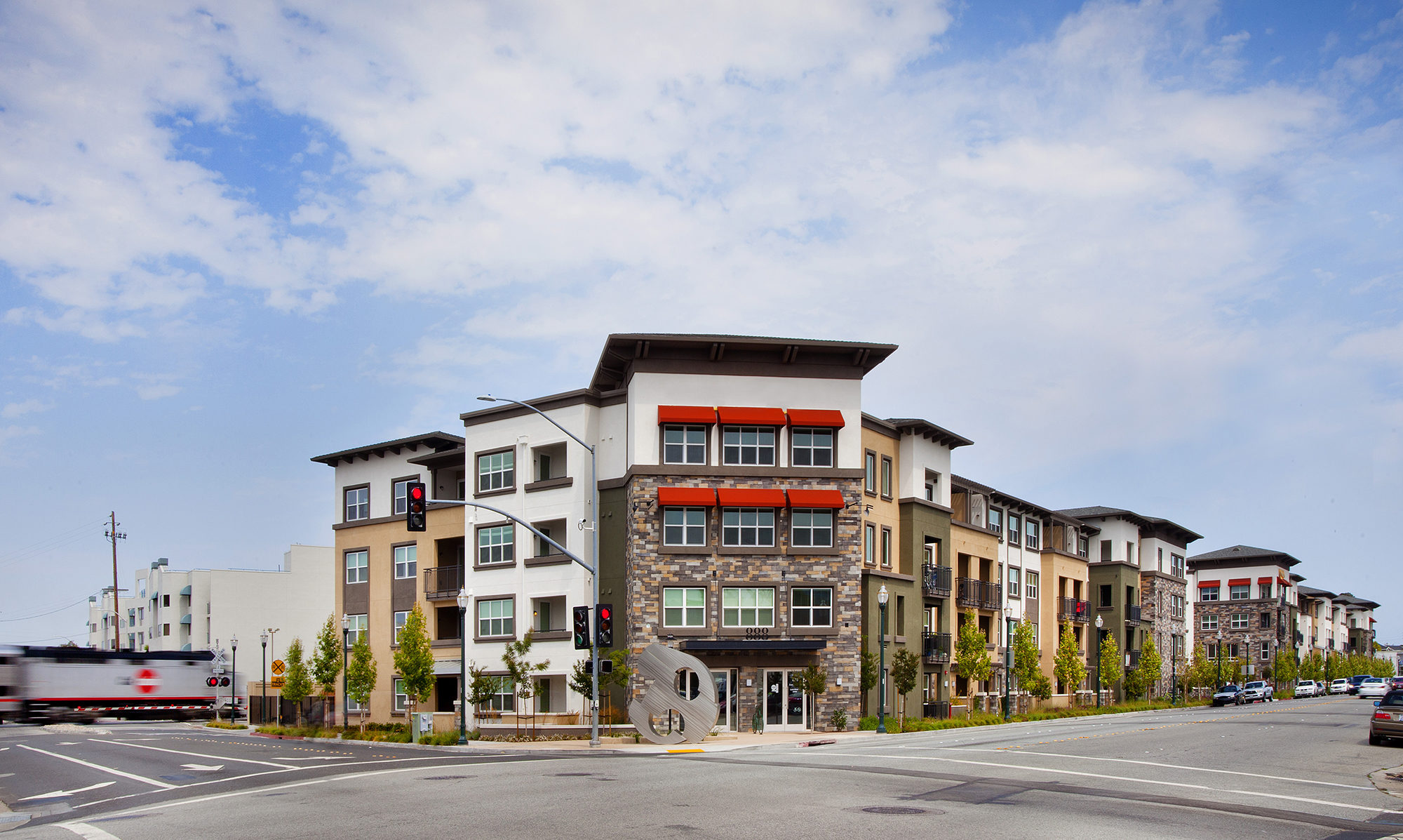Front view of walk up with varying green, tan and stone along the facade